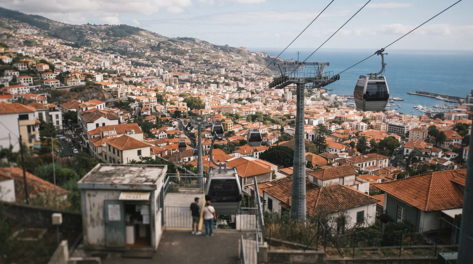 Cable car cabins climbing above Funchal towards Monte, seen from the lower station in Funchal
