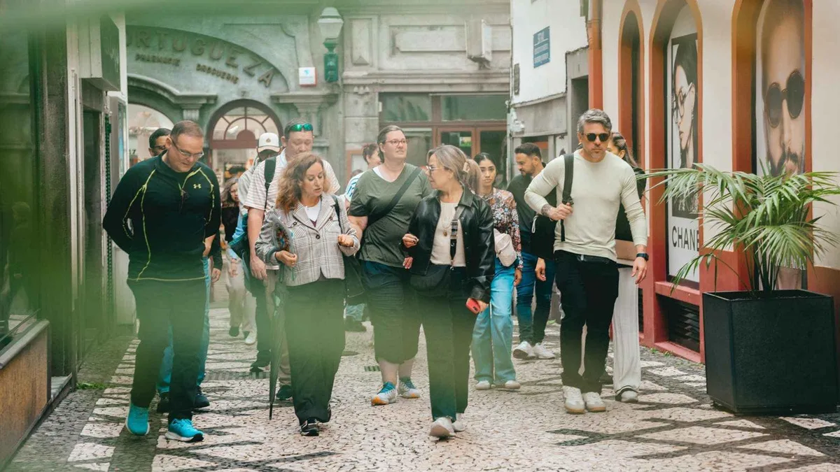 A guide leading a small group past market stalls in Funchal on a Taste Funchal food, wine and cultural tour in Funchal, Madeira