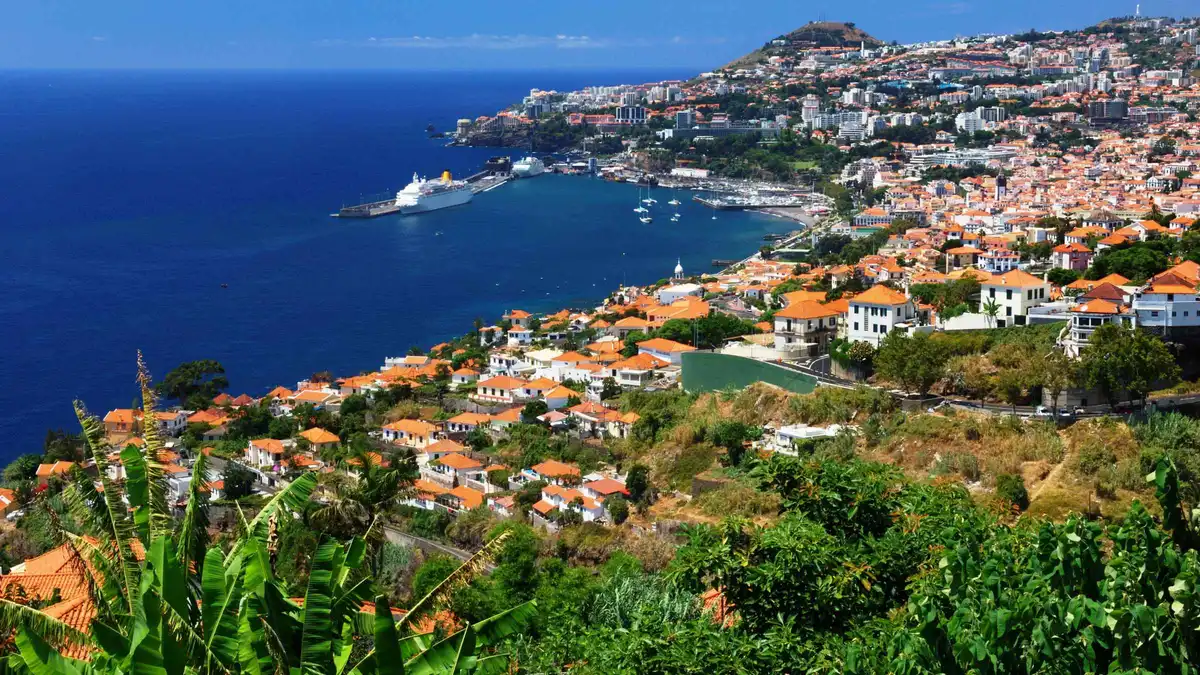 A yellow open-top sightseeing bus overlooking the Cabo Girão cliffs on a Funchal hop-on hop-off bus tour in Câmara de Lobos, Madeira