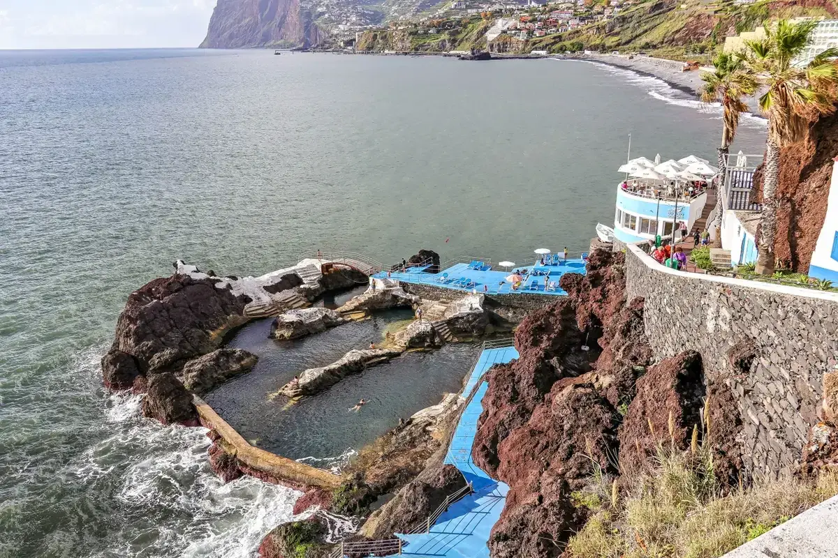 The natural volcanic-rock pools and sundeck of Doca do Cavacas bathing complex on the Funchal coast, Madeira, Portugal