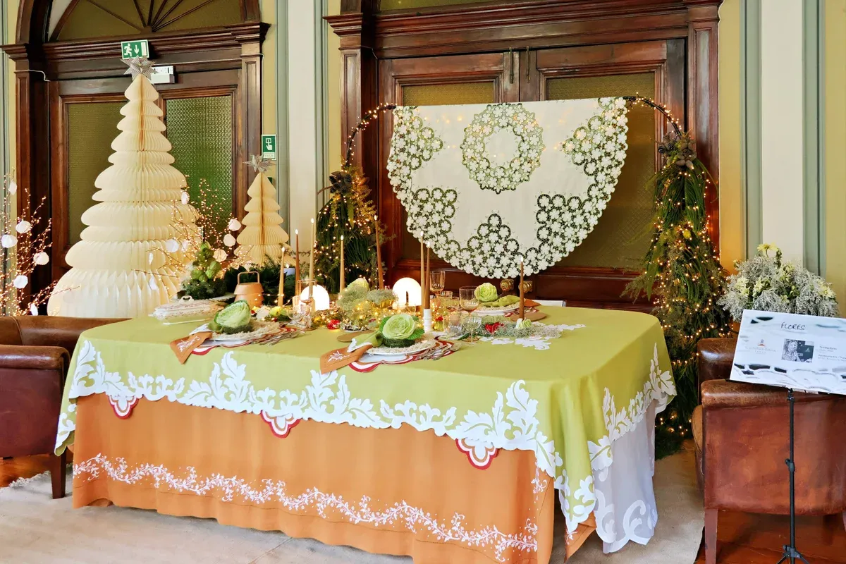 Fine hand-embroidered white Madeira embroidery lacework displayed on a table at a public exhibition in Funchal, Madeira, Portugal
