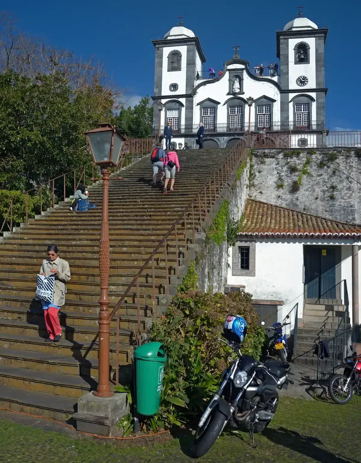 Visitors descending the long stone staircase from Monte Church in Funchal, Madeira, Portugal