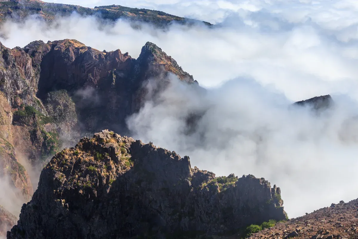 Clouds filling the valleys below the rocky ridge of Pico do Arieiro near Funchal, Madeira