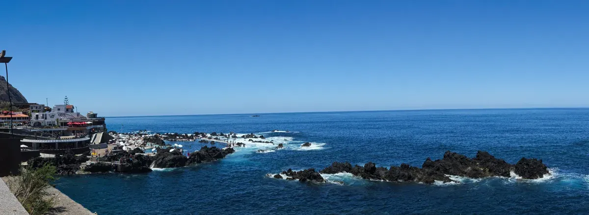 Waves washing into the volcanic natural swimming pools of Porto Moniz on a day trip from Funchal, Madeira