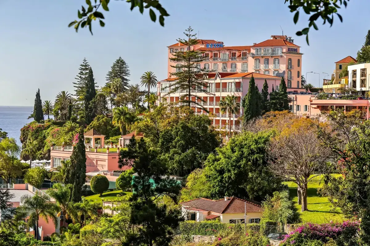 The pink facade of Reid's Palace hotel above the Atlantic coast in Funchal, Madeira, Portugal, where afternoon tea is served